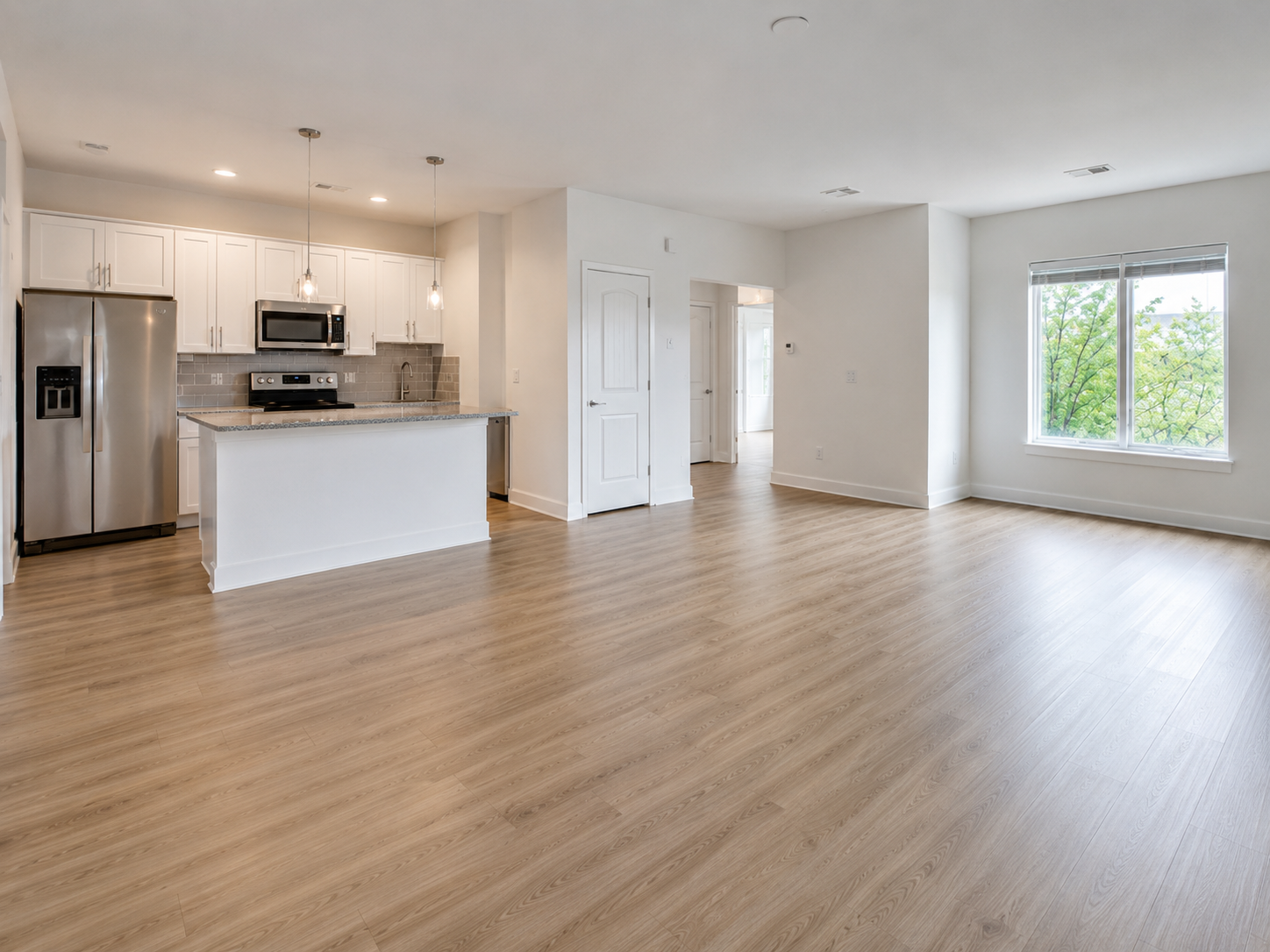 Freshly cleaned, move-in ready apartment interior with hardwood floors and open kitchen